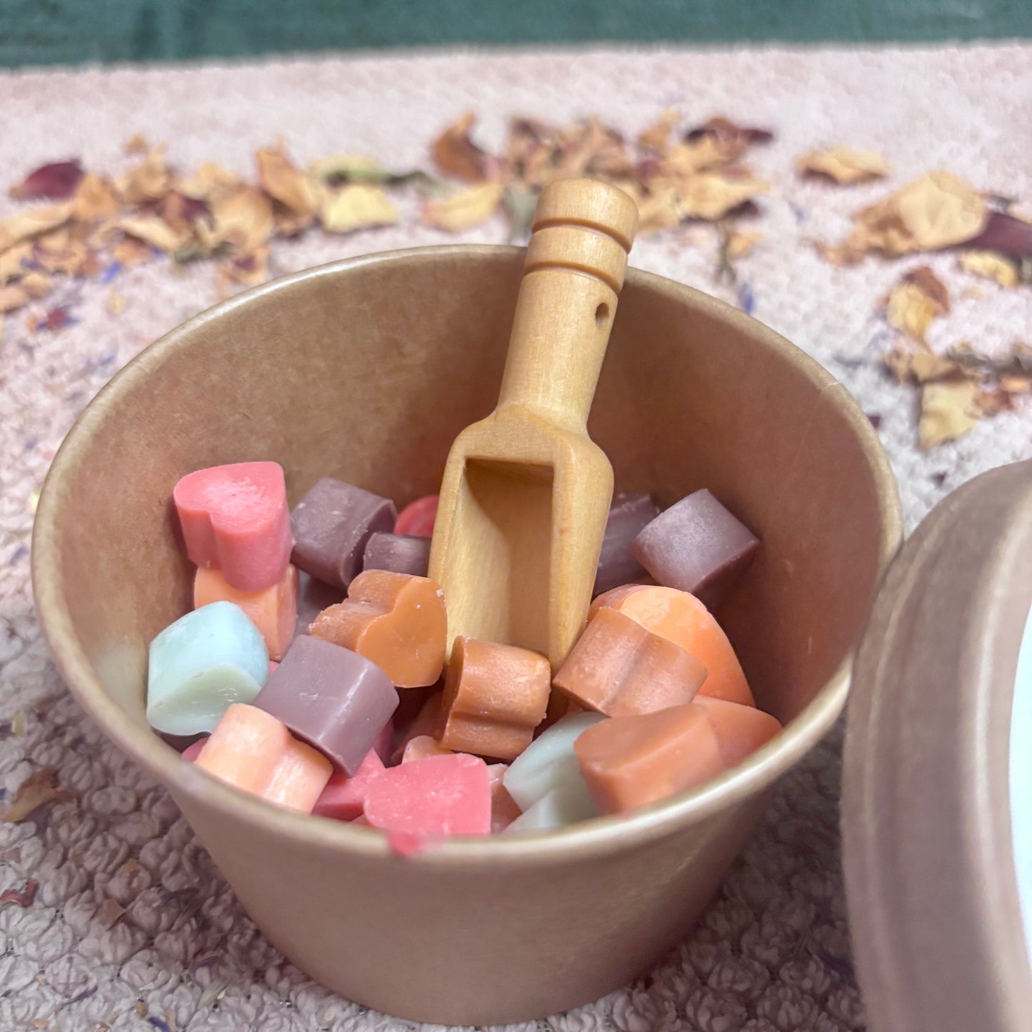 Close-up of Autumn Embrace soy wax melts shaped like leaves, pumpkins and acorns