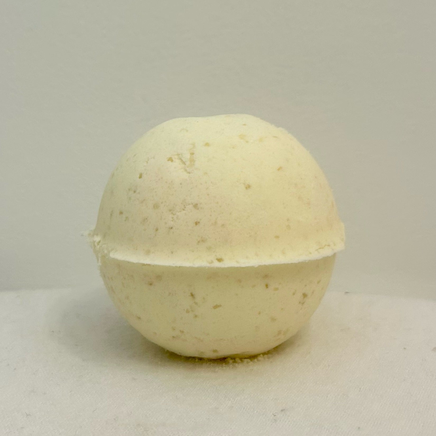"A close-up of the GoodVibes Bath Bomb, handcrafted with a natural texture and bursting with the fresh, uplifting scents of lemon, lime, and geranium essential oils."