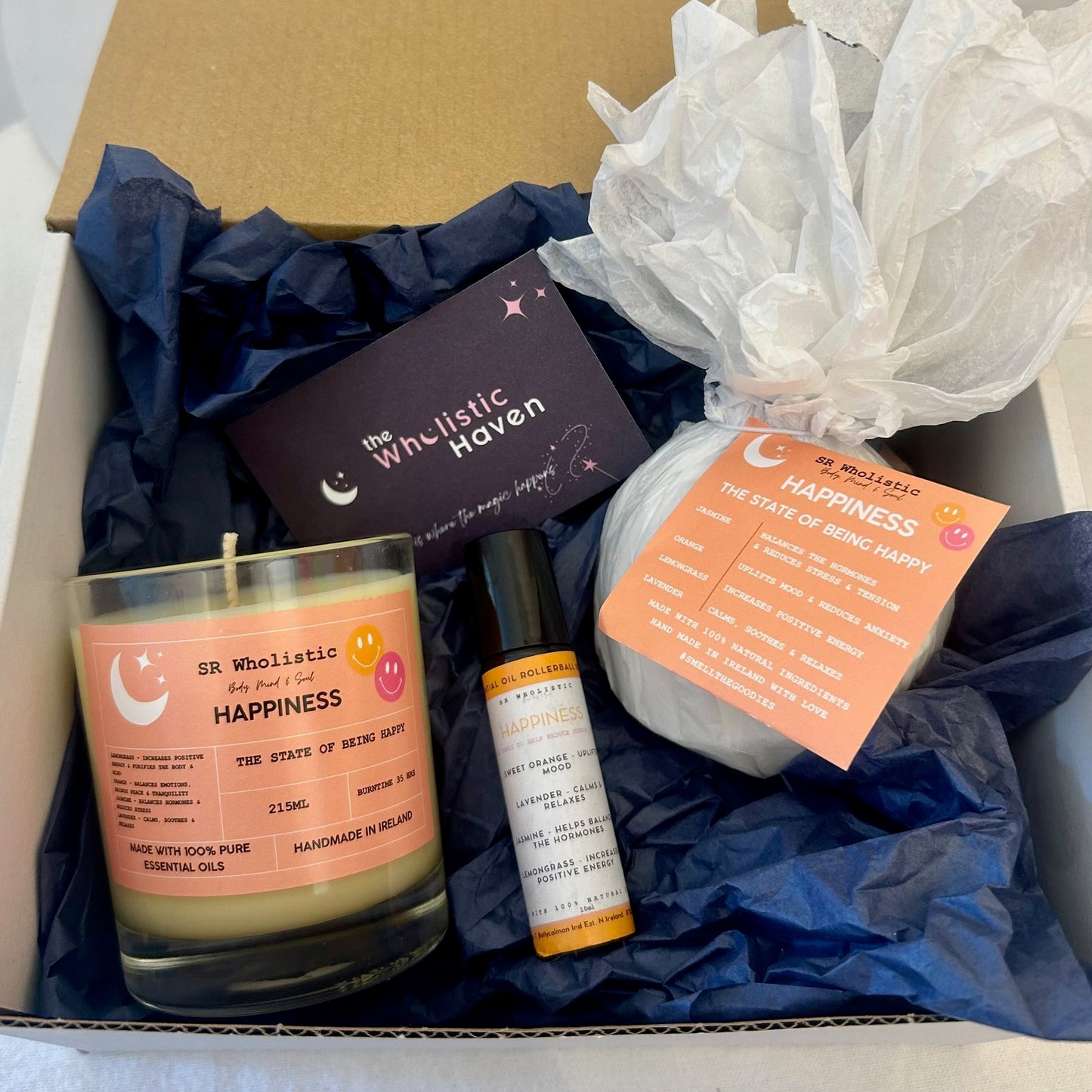 "Open Happiness Gift Set gift box showing joyful arrangement of aromatherapy candle, bath bomb, and rollerball – a vibrant blend designed to lift the spirit."