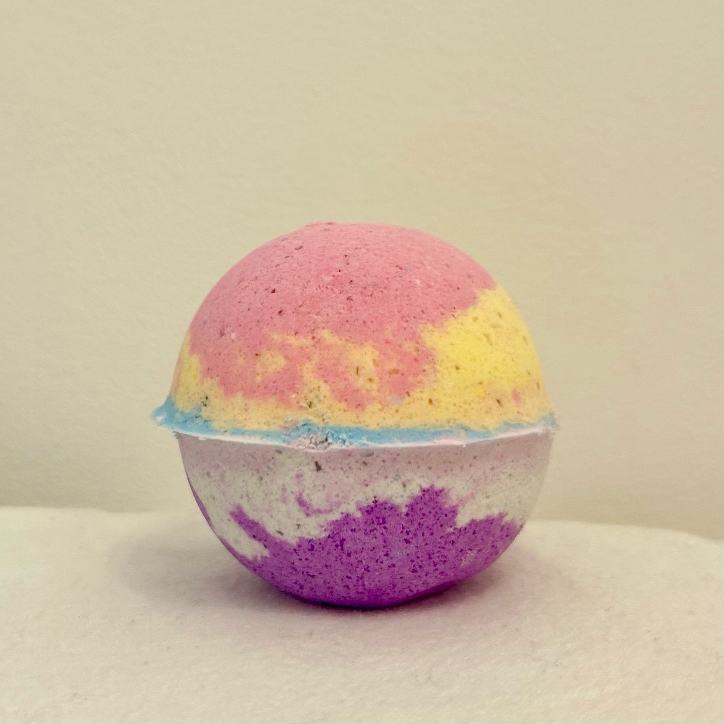 "A vibrant, multi-colored Kids Only Bath Bomb designed for sensitive skin, handcrafted with 100% natural ingredients and calming lavender essential oil for a soothing bath experience."