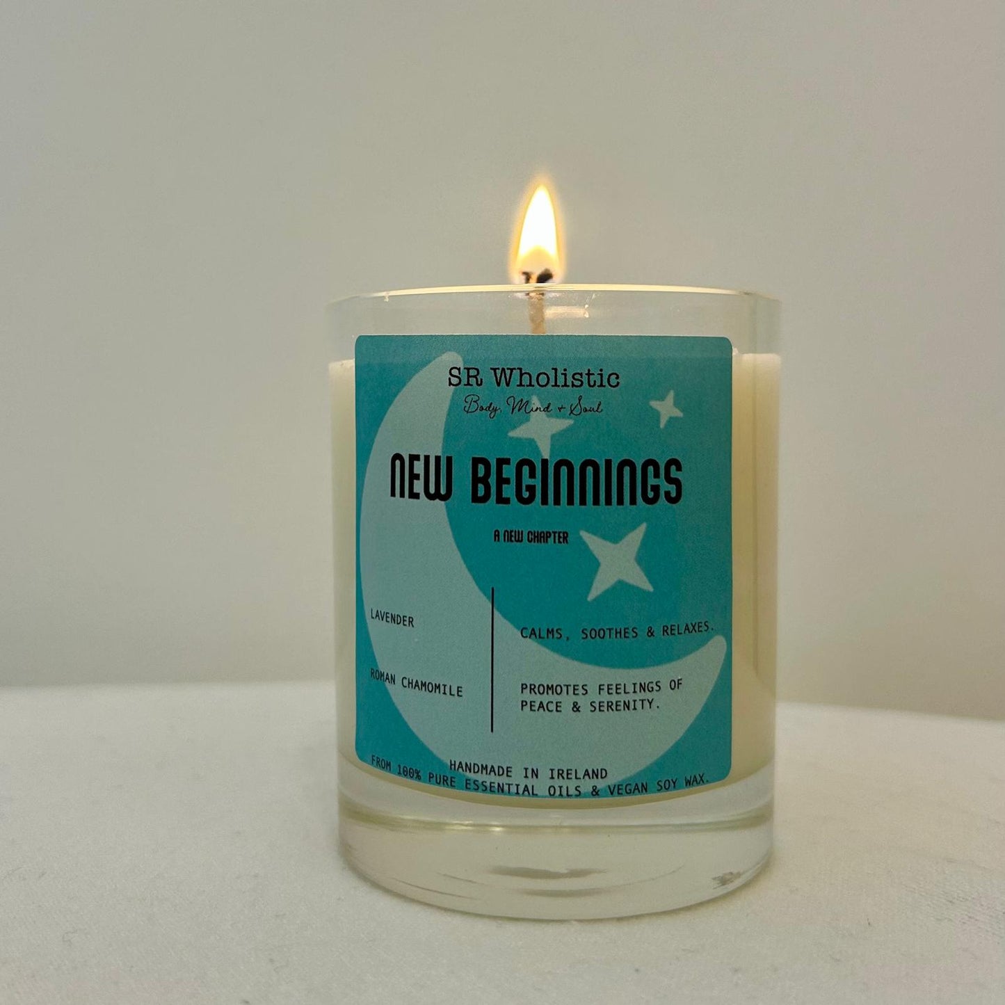 "New Beginnings candle burning gently, casting a soft, soothing glow perfect for fresh starts and relaxation."