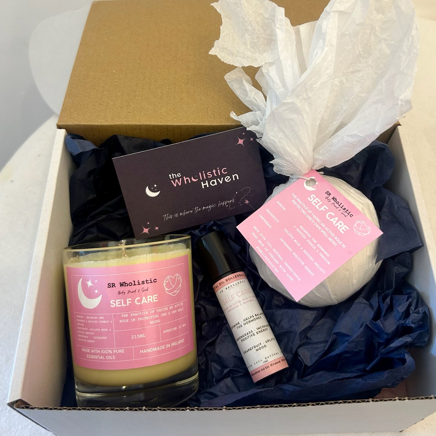 "Self-care gift box with candle, bath bomb, and rollerball blend arranged inside – scented with jasmine, grapefruit, and lemongrass for a vibrant and uplifting wellness treat."
