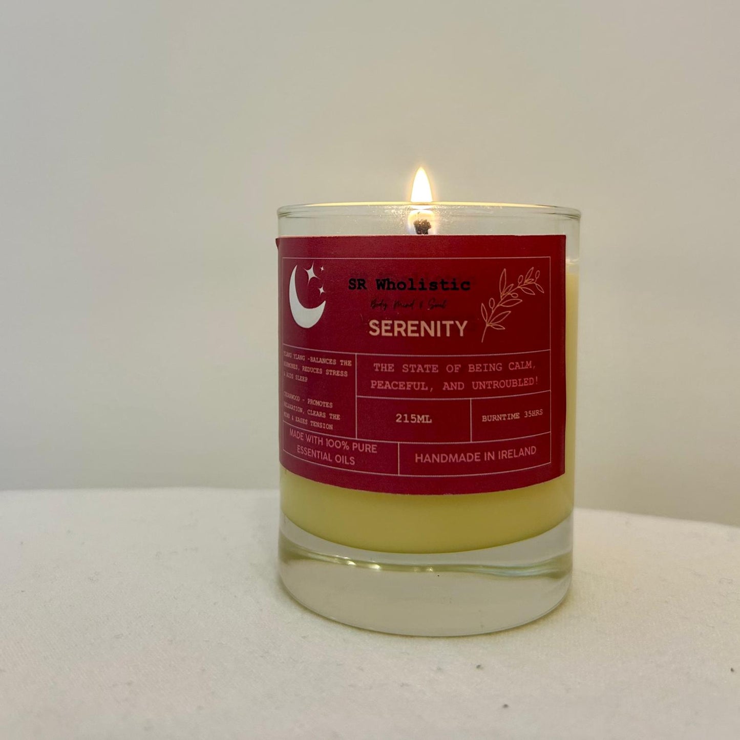 "Serenity candle burning softly, casting a gentle, soothing glow perfect for relaxation and unwinding."
