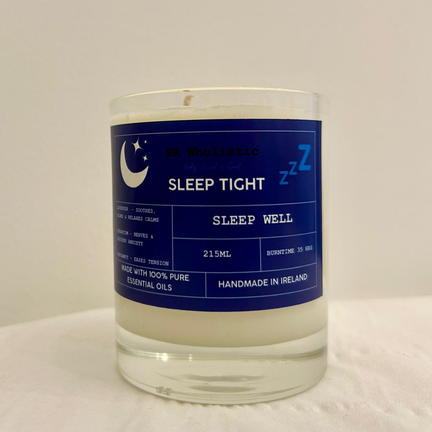 "Sleep Tight candle in a clear glass jar with label clearly visible, standing alone on a neutral background."