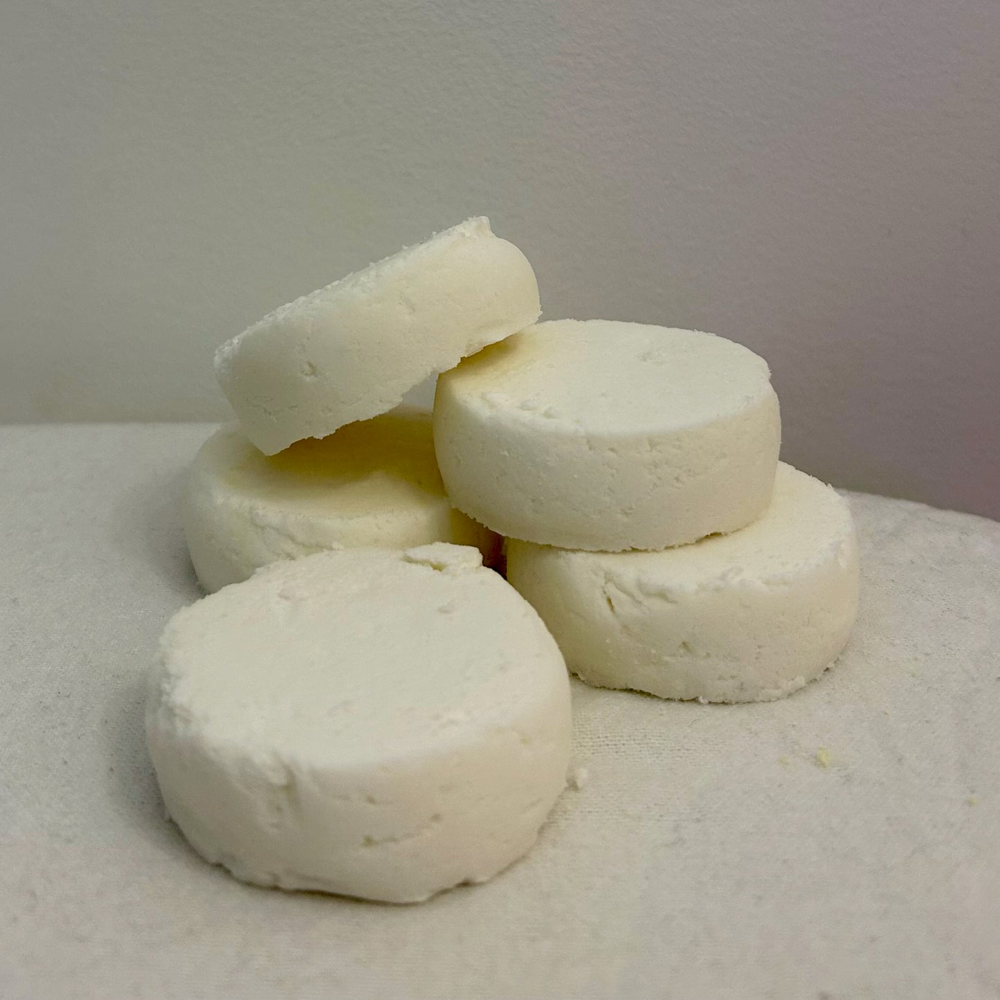Five round Breathe Shower Bombs displayed on a white background, made with peppermint, eucalyptus, and lemon essential oils