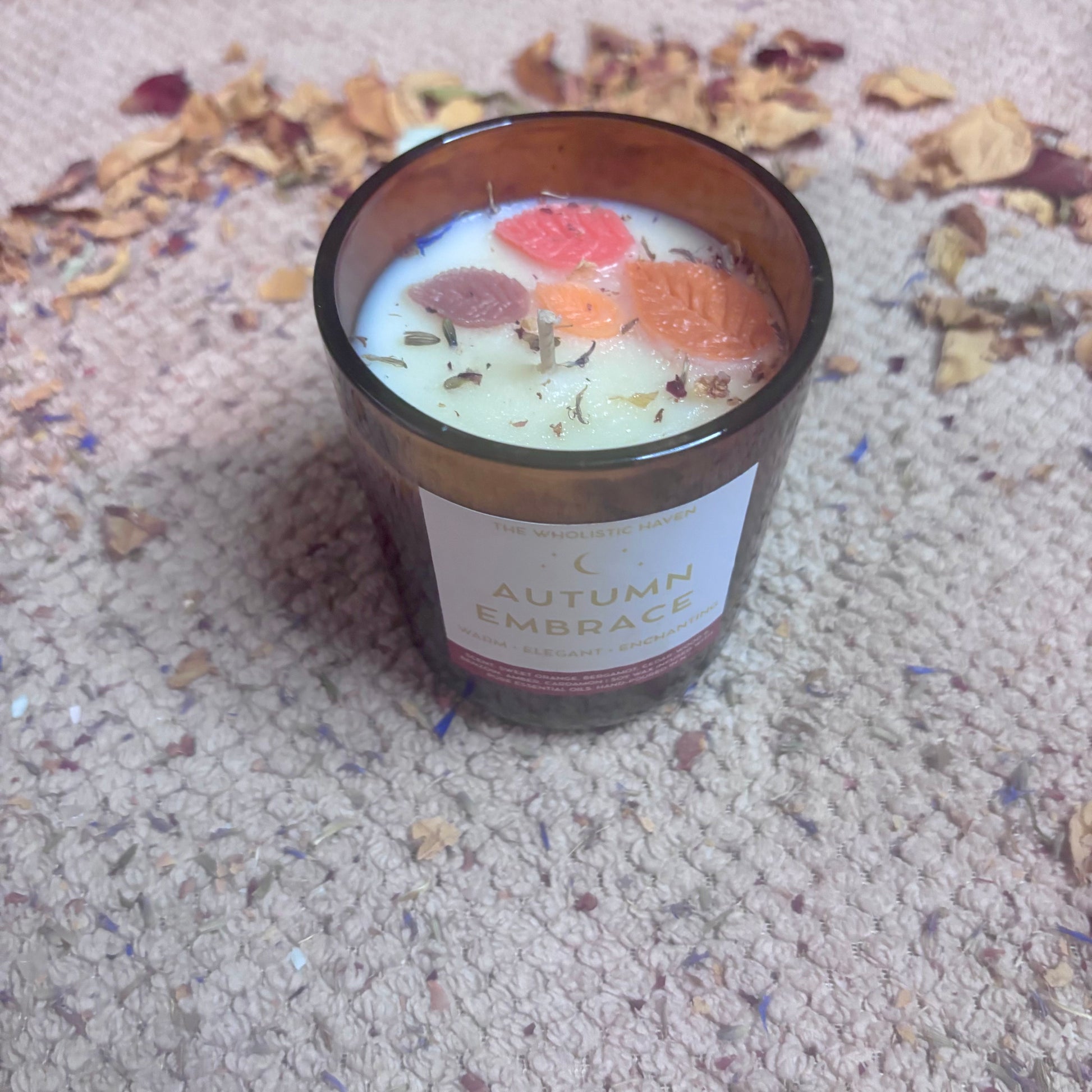 Autumn Embrace aromatherapy candle styled with autumn leaves and cosy décor