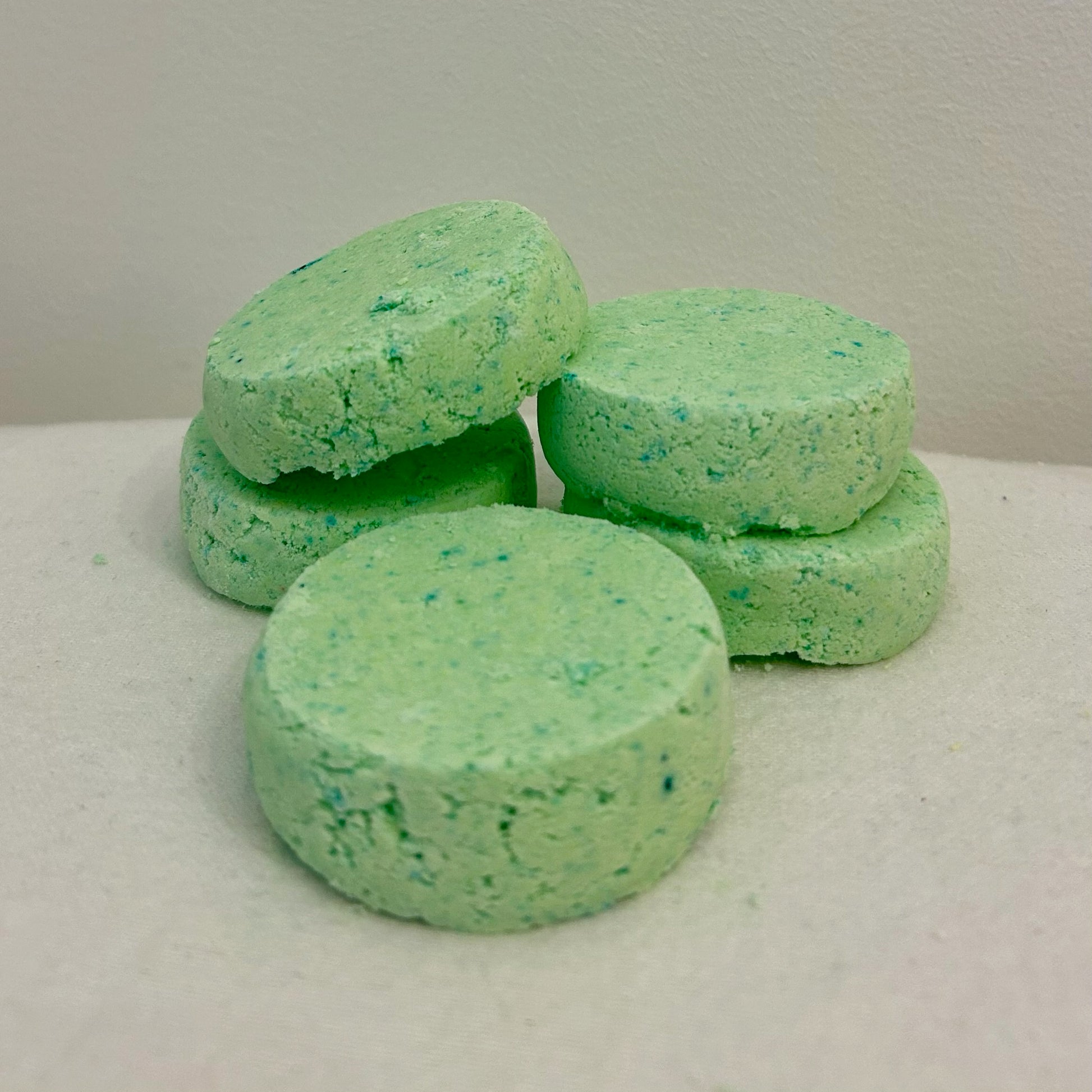 Five round Chillax & Relax Shower Bombs displayed on a white background, made with geranium, bergamot & cedarwood essential oils