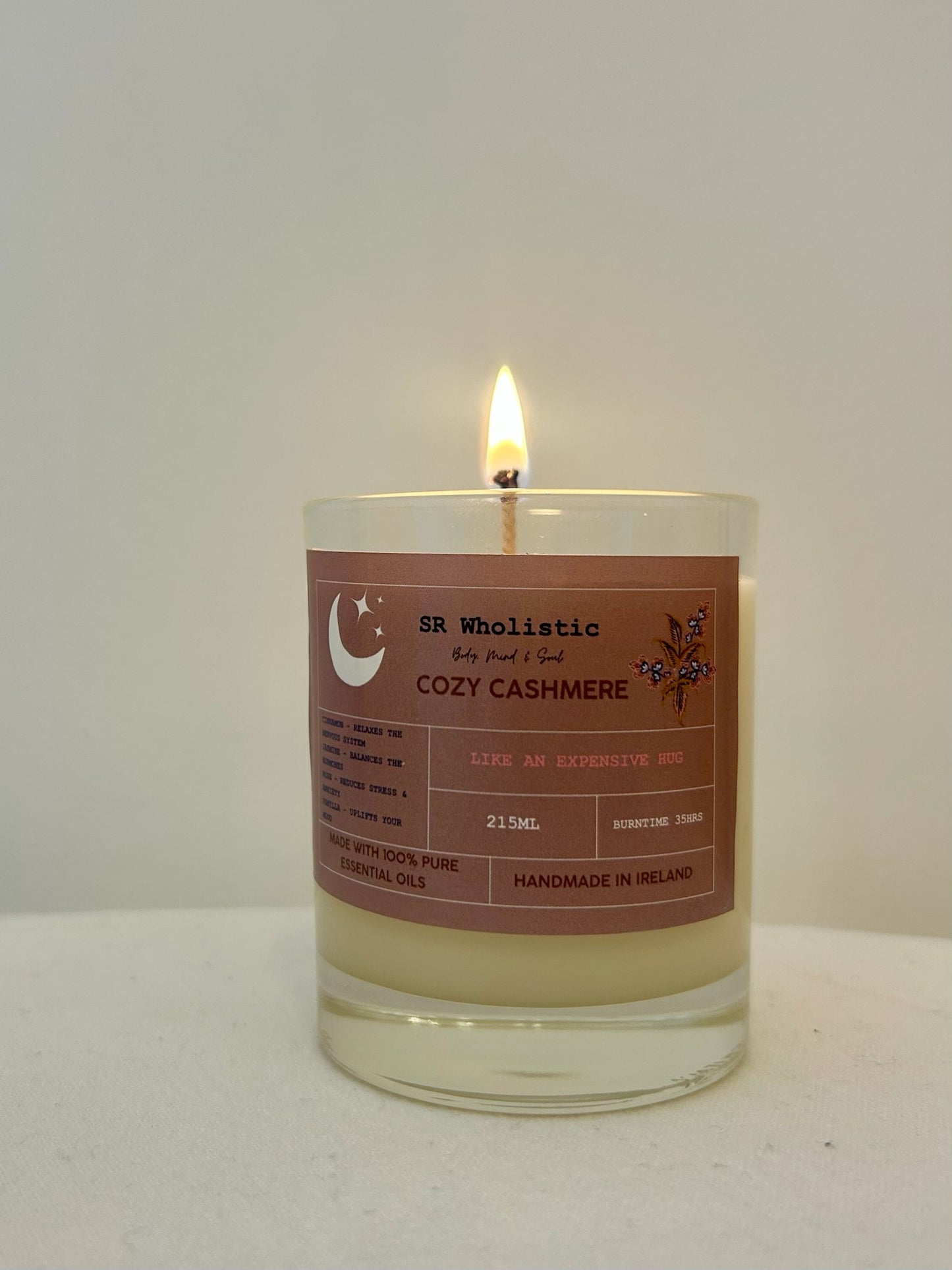"Cosy Cashmere candle burning softly, casting a gentle, soothing glow perfect for relaxation and unwinding."