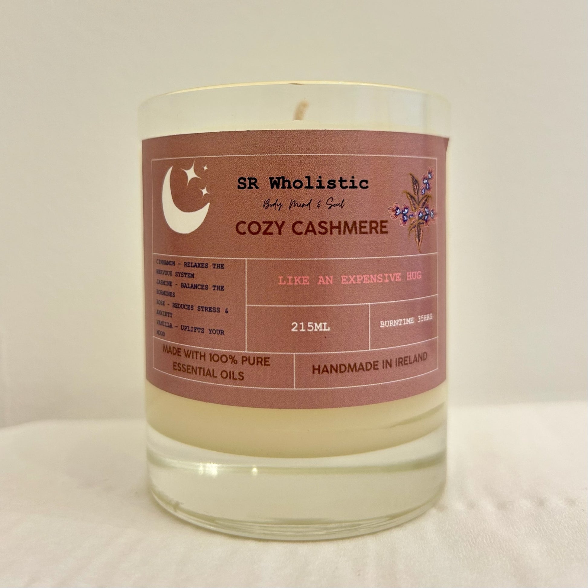 "Cosy Cahsmere candle in a clear glass jar with label clearly visible, standing alone on a neutral background."