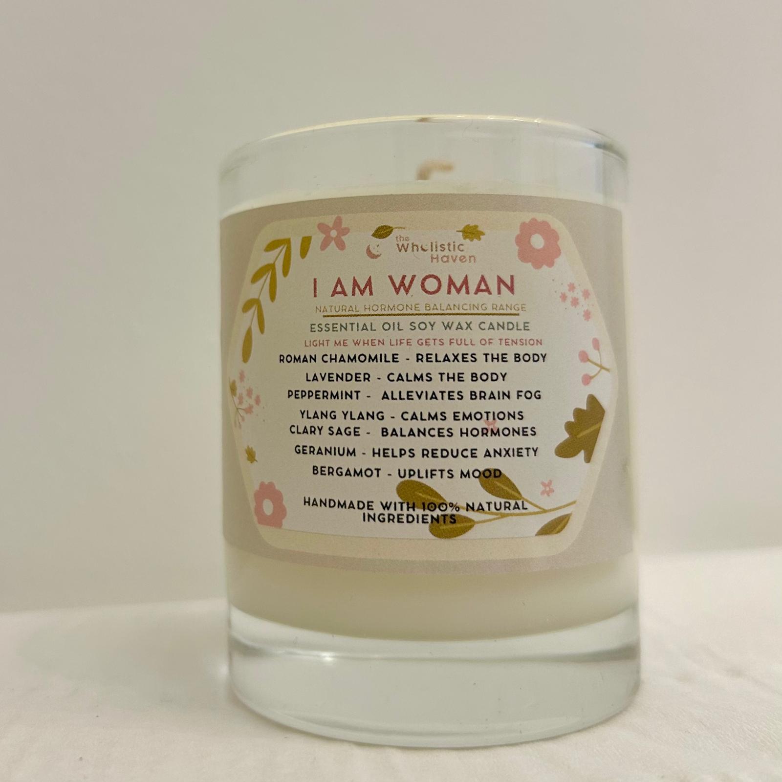 "I Am Woman candle in a clear glass jar with label clearly visible, standing alone on a neutral background."
