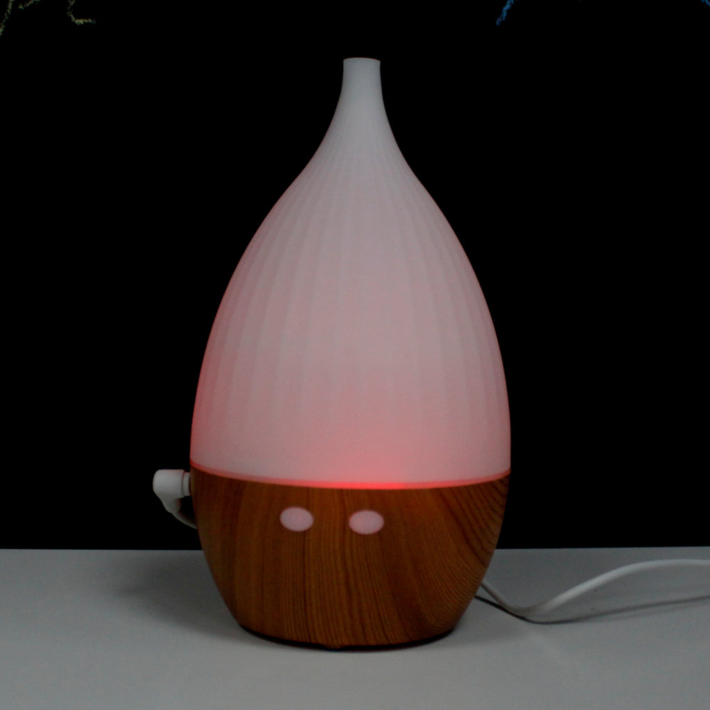 White and wooden diffuser with a red light on a dark background