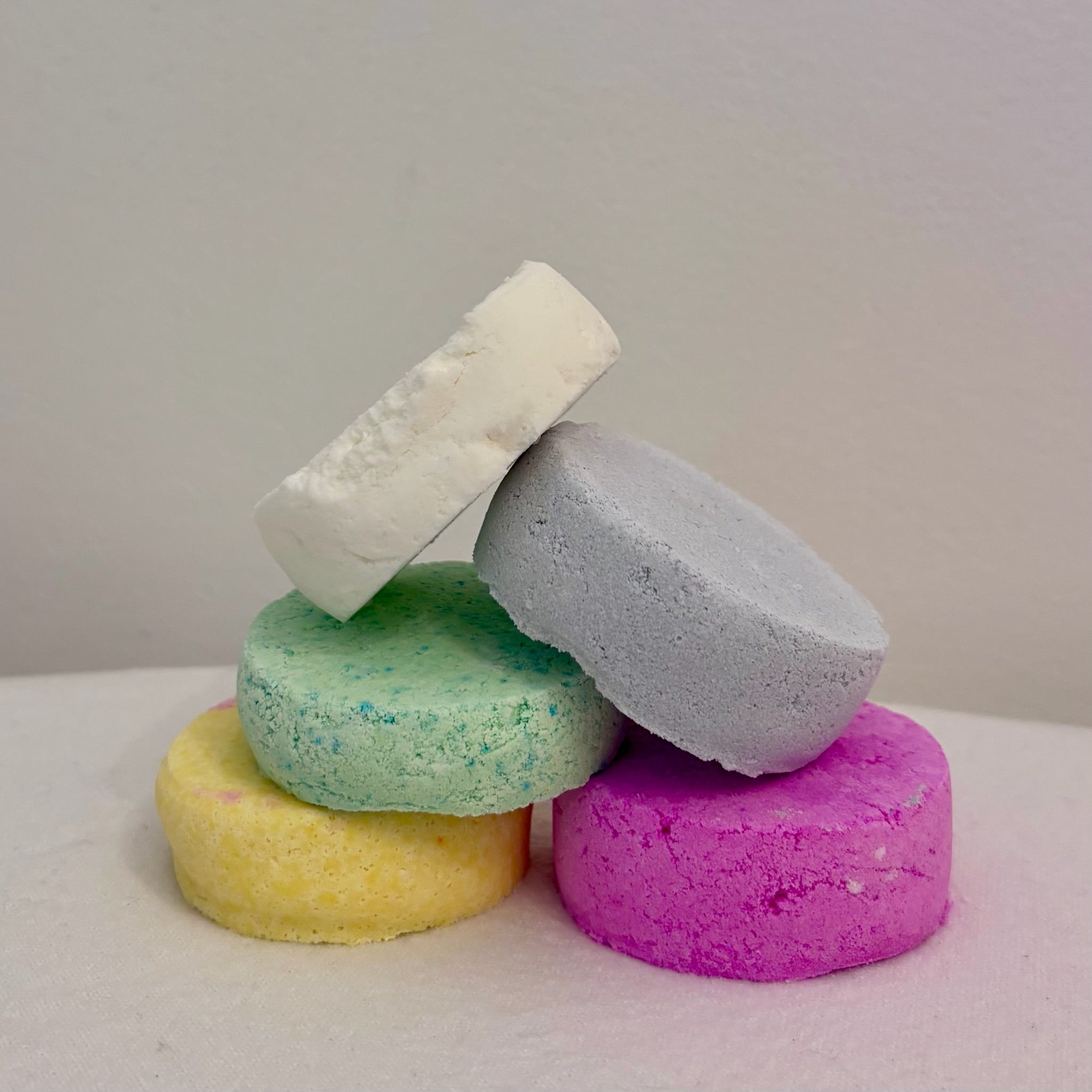 Five individual aromatherapy shower bombs arranged neatly to display assorted colours and textures