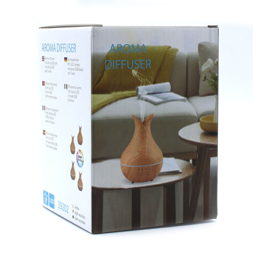 Aroma diffuser packaging with a wooden diffuser on a table in a living room setting.