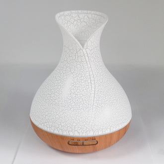 A white ultrasonic atomizer with a shell effect design, featuring a wood-like base and a crackle pattern finish. It has a sleek, modern shape with a curved top and a front-facing control panel.