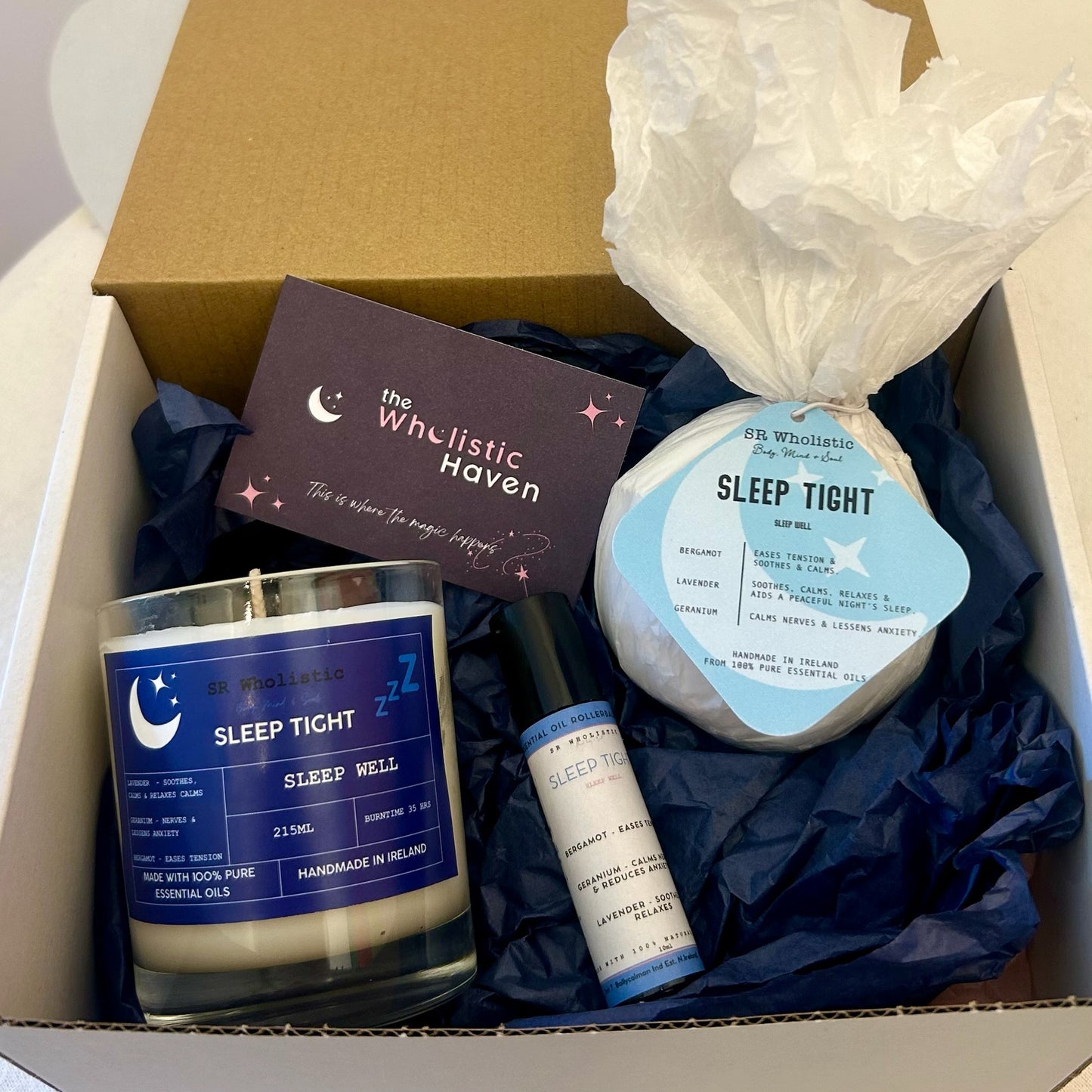 "Sleep Tight Gift Set neatly arranged inside an open gift box, including a relaxing candle, bath bomb, and aromatherapy rollerball – perfect for a restful bedtime ritual."