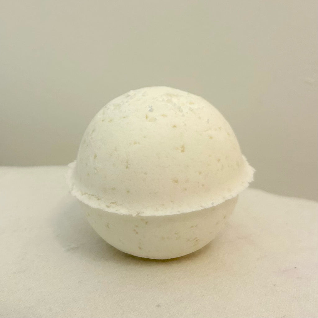 "A close-up of a smooth, earthy-colored Manly Bath Bomb, highlighting its natural texture and handcrafted design, scented with peppermint, eucalyptus, and lemon essential oils."