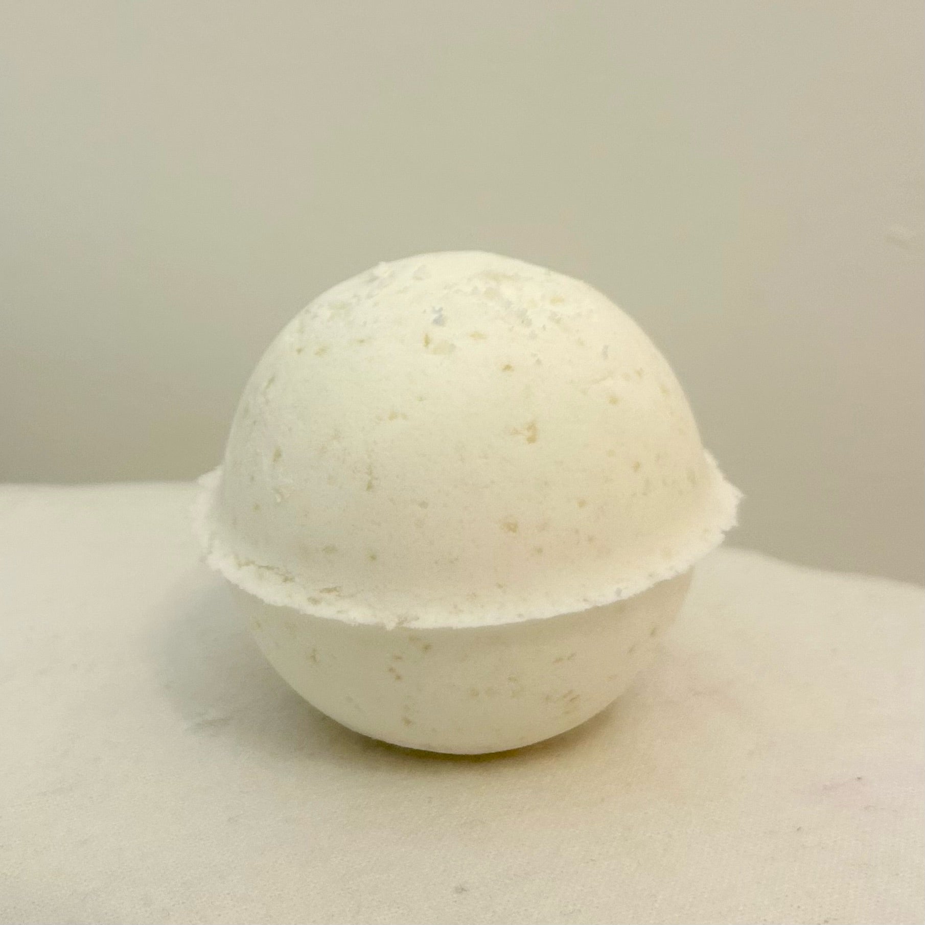 "A close-up of a smooth, earthy-colored Manly Bath Bomb, highlighting its natural texture and handcrafted design, scented with peppermint, eucalyptus, and lemon essential oils."