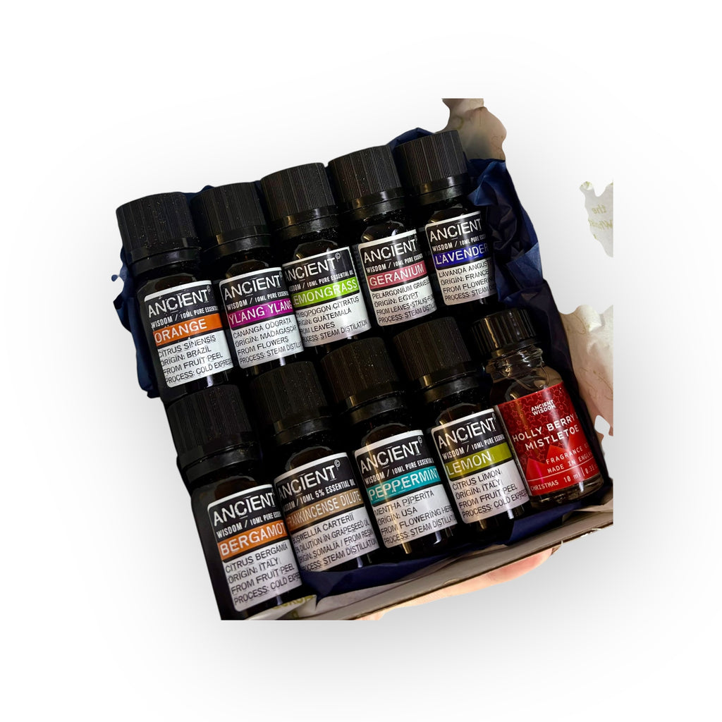 Set of essential oil bottles in a box with visible labels on a white background