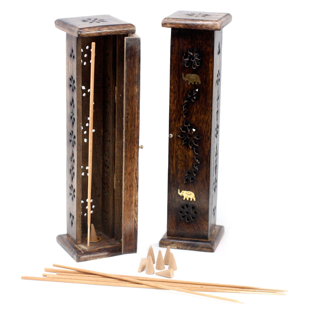 Wooden incense burner with decorative elements and incense sticks on a white background