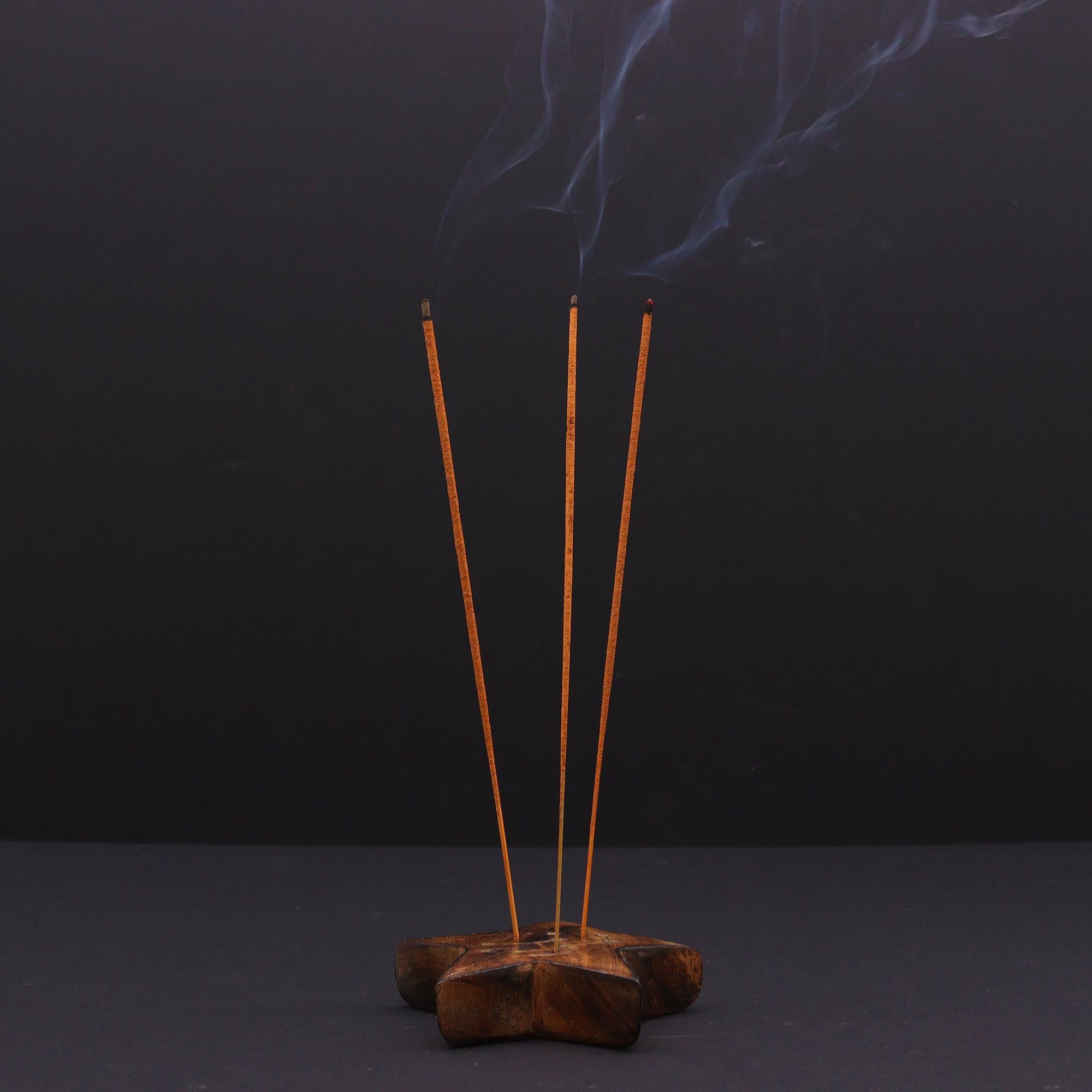 Incense sticks with smoke on a dark background