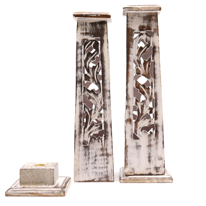 Two decorative wooden pillars with intricate carvings on a white background
